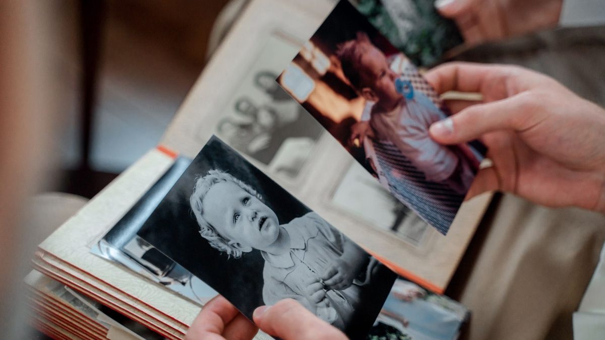 Hender som blar i et album med gamle fotografier
