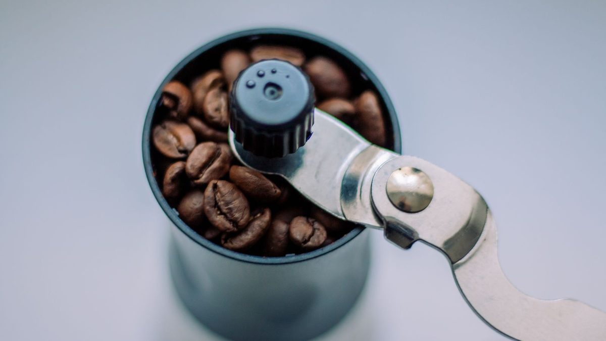 Håndkvern fylt med hele kaffebønner