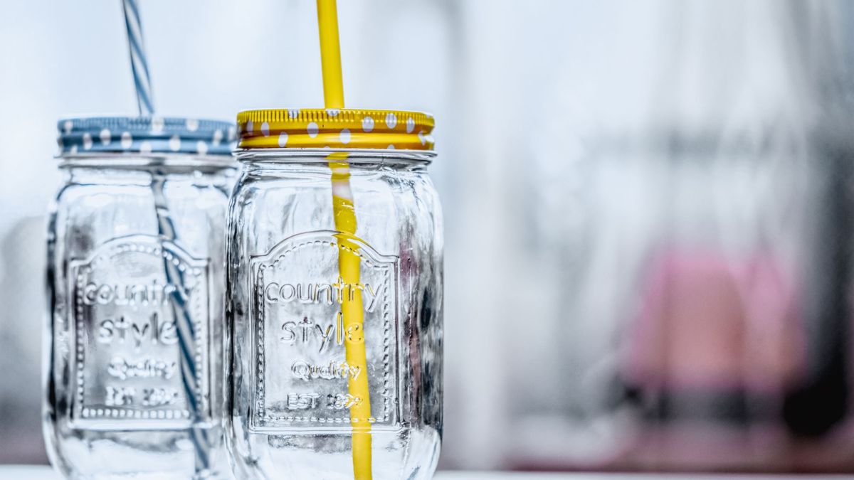 To mason jar-glass med metallokk og sugerør