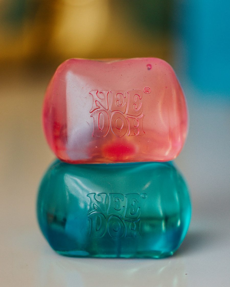 En rosa og en turkis NeeDoh Nice Cube stablet oppå hverandre
