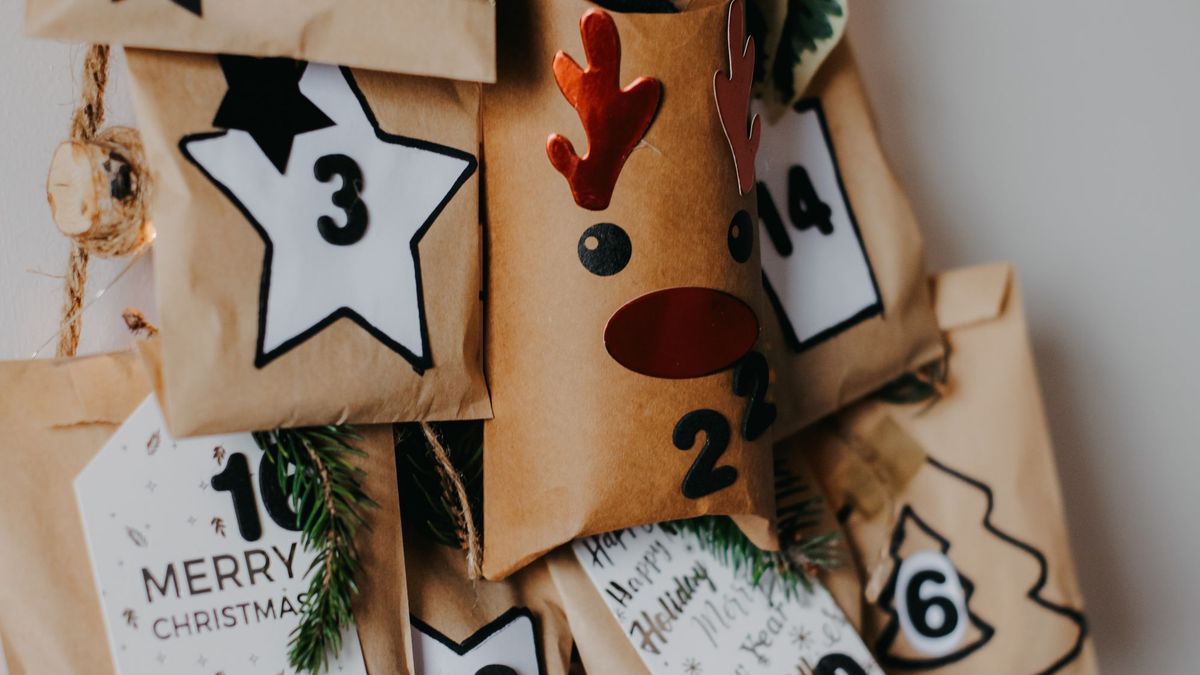 Pakkekalender av brune papirposer med tall, stjerner og granbar