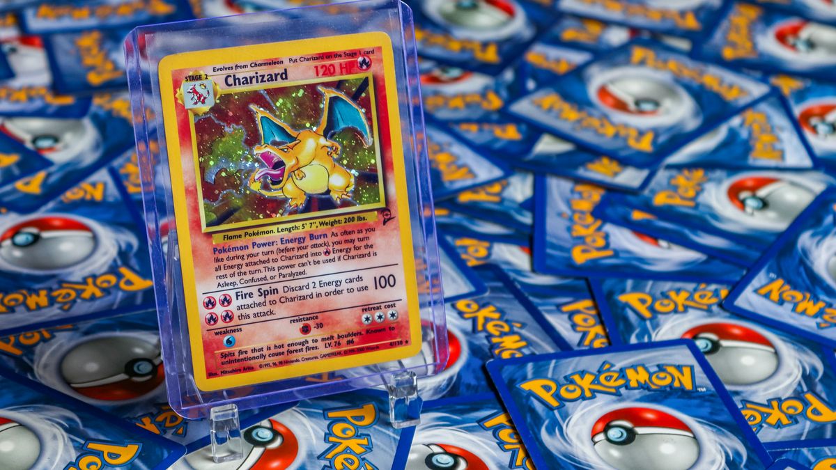 Et Charizard-kort i plastholder oppå en haug med Pokémon-kort