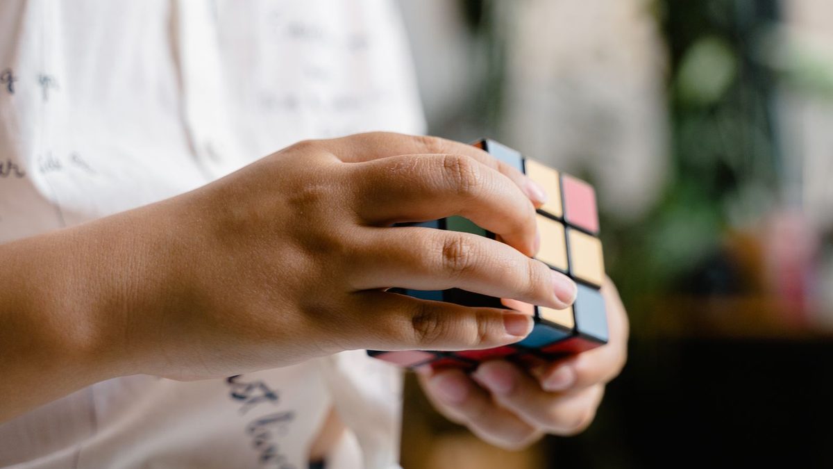 Hender som vrir på en Rubiks kube