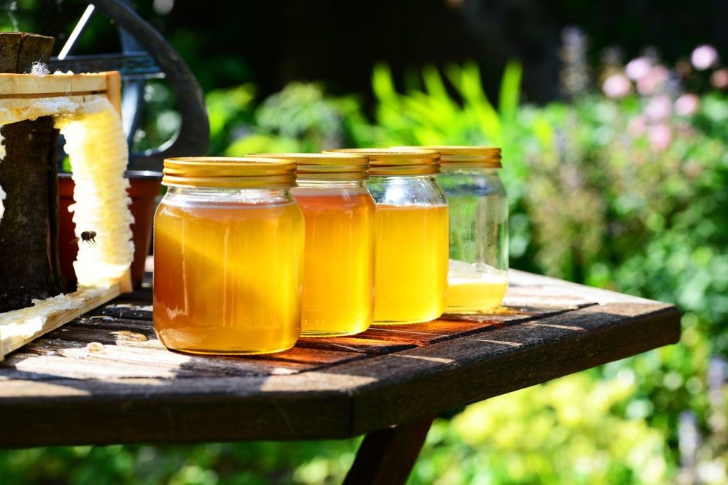 Honning, også kalt for flytende gull, i glasskrukker på terassebord